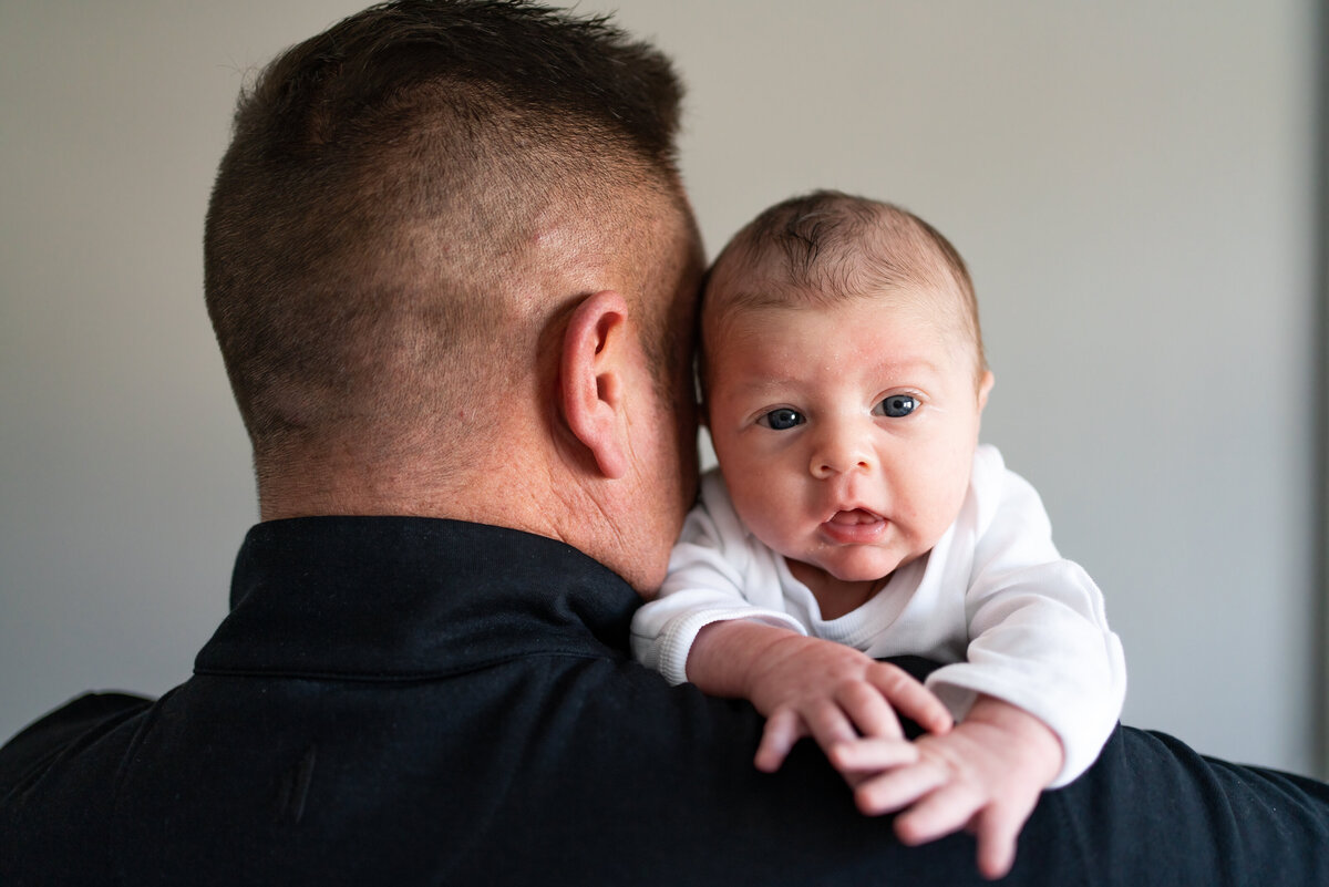 Baby boy perched on dad's shoulder