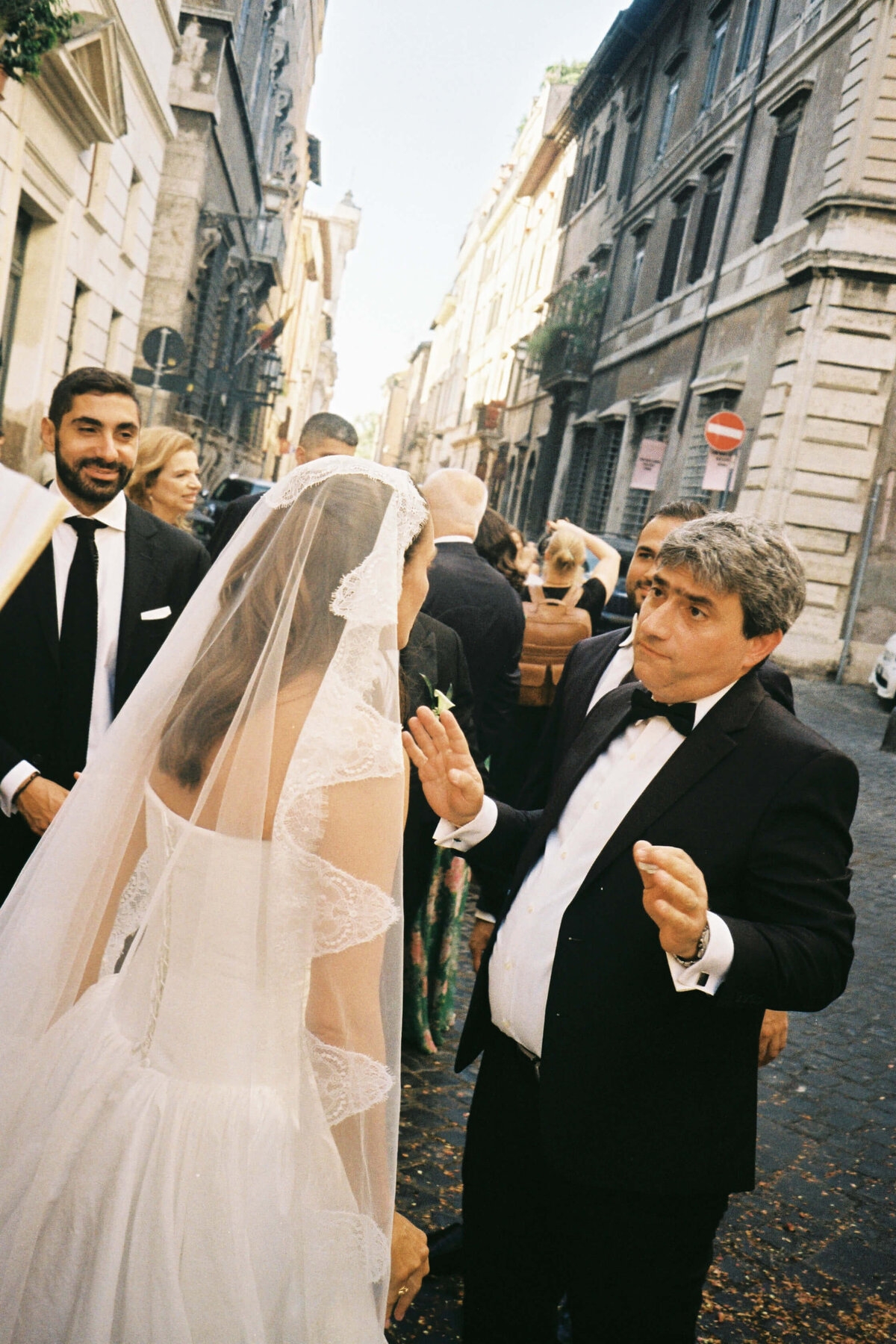 Father of the bride hugging guests during church exit celebration

