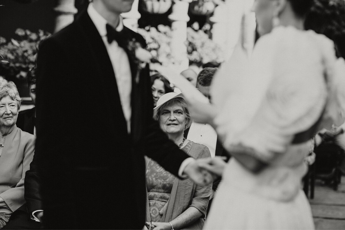 Mother og room smiles as couple reads vows