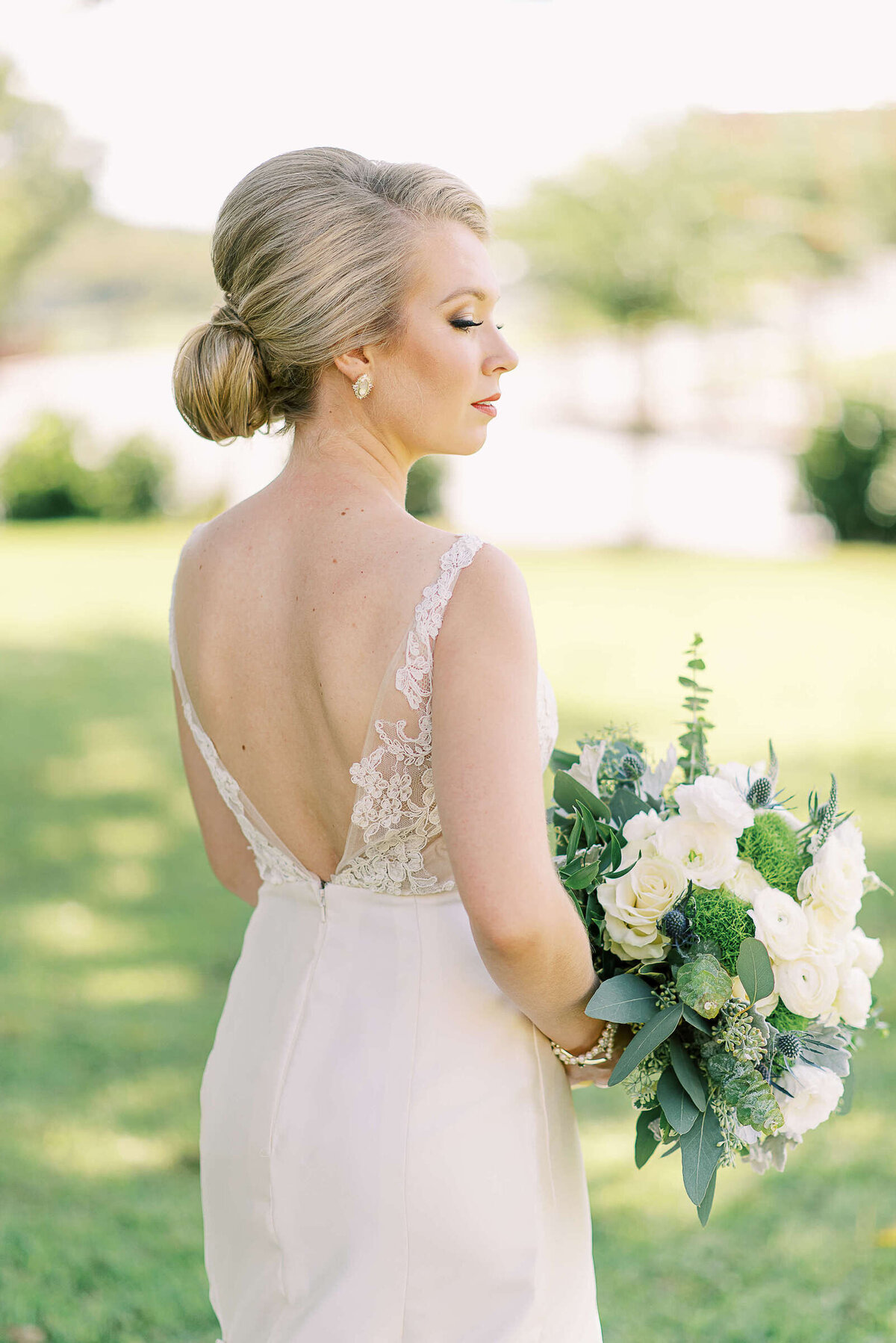 Elegant bride with blonde updo wearing backless dress
