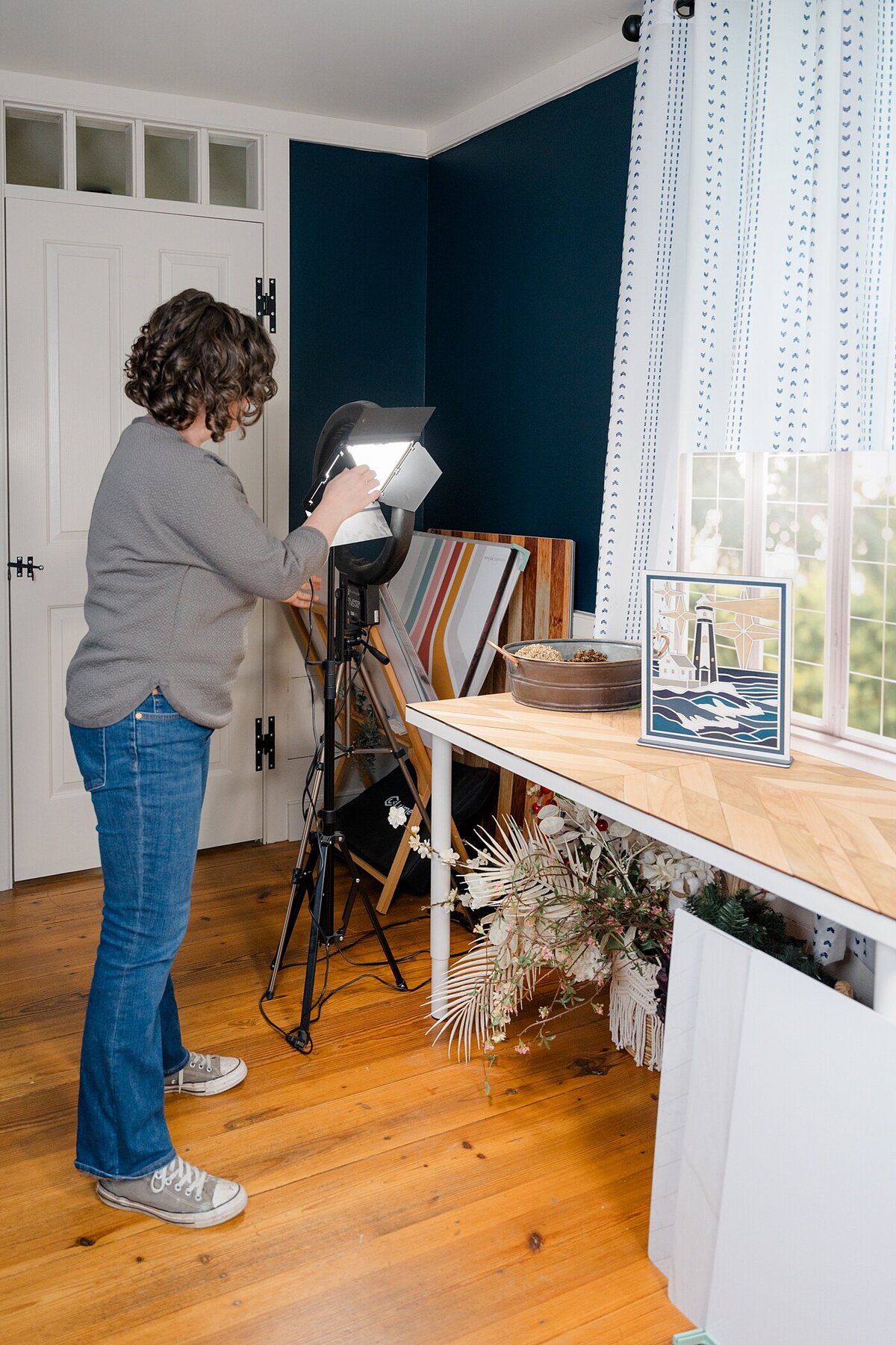 Columbus photographer captures behind the scenes photos with a light shining on her product while she is photographing her products