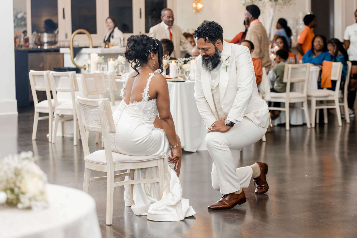 The newlyweds share a sweet moment as they cut their wedding cake, surrounded by guests.