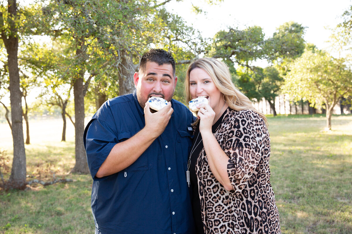 An Austin wedding photographer capturing intimate moments of a man and woman enjoying donuts in a scenic field.