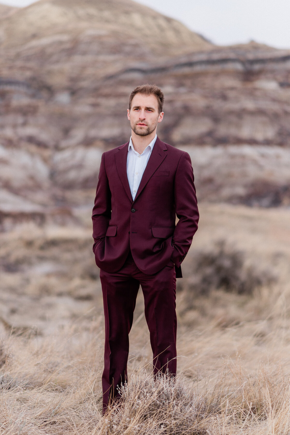 Groom wearing burgundy suit in Drumheller, Alberta.