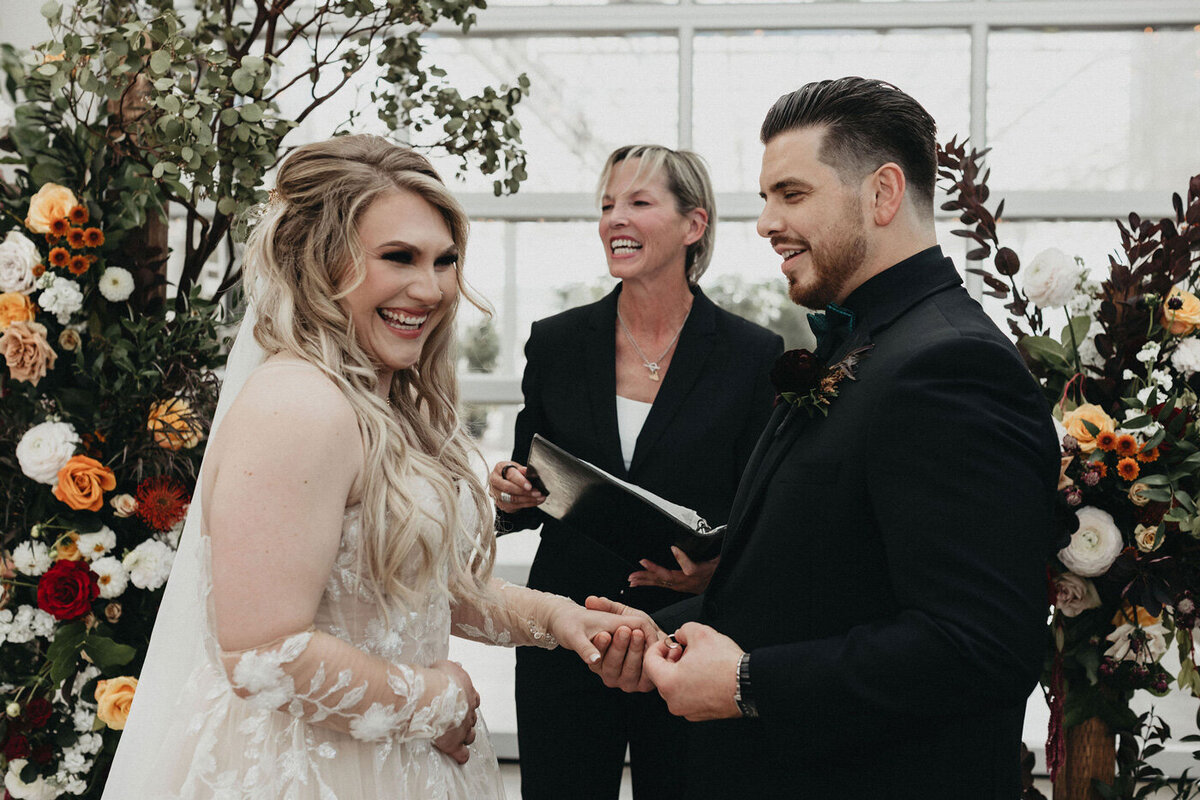 Bride and groom smiling while exchanging vows.