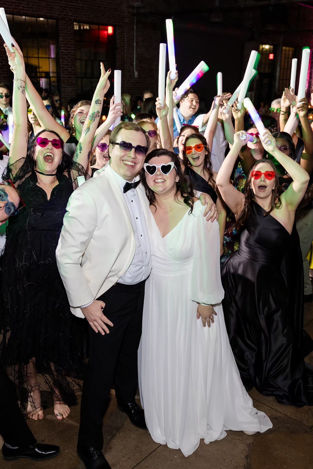 Guests cheer for bride and groom on the dance floor at reception