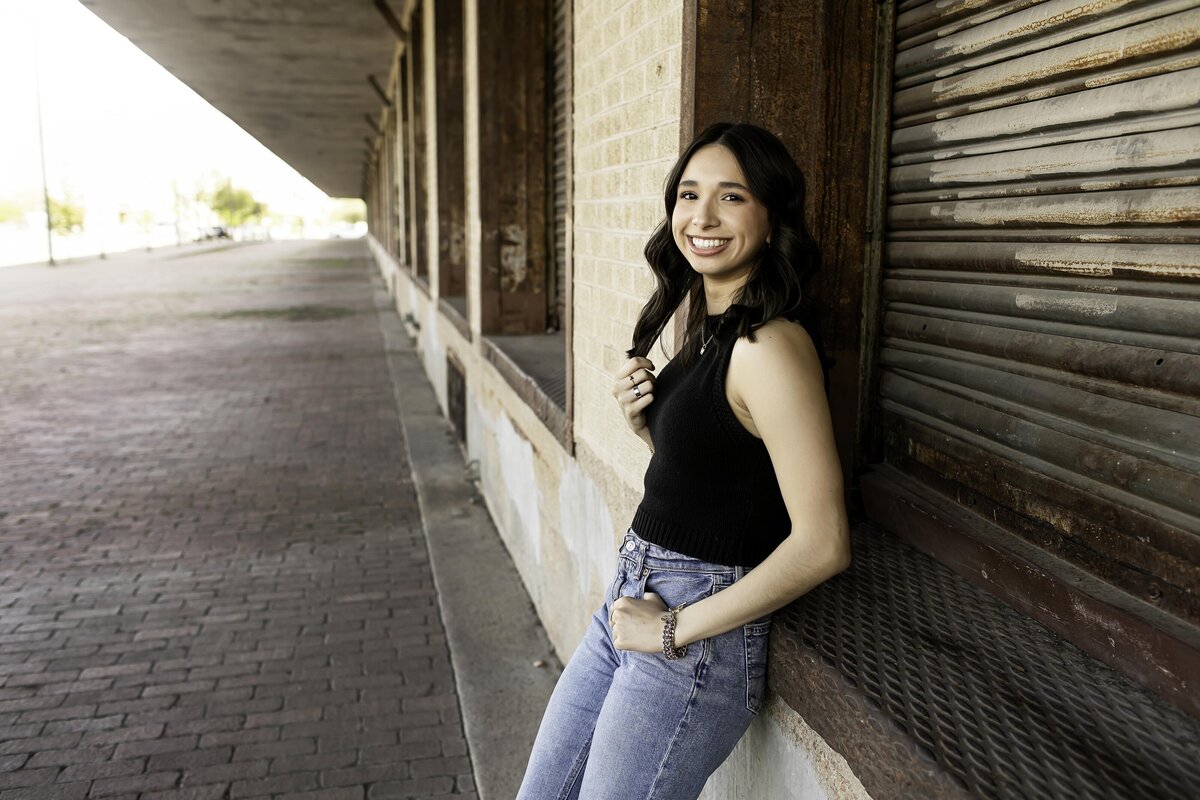 A high school senior poses against a neutral background, allowing their personality to shine