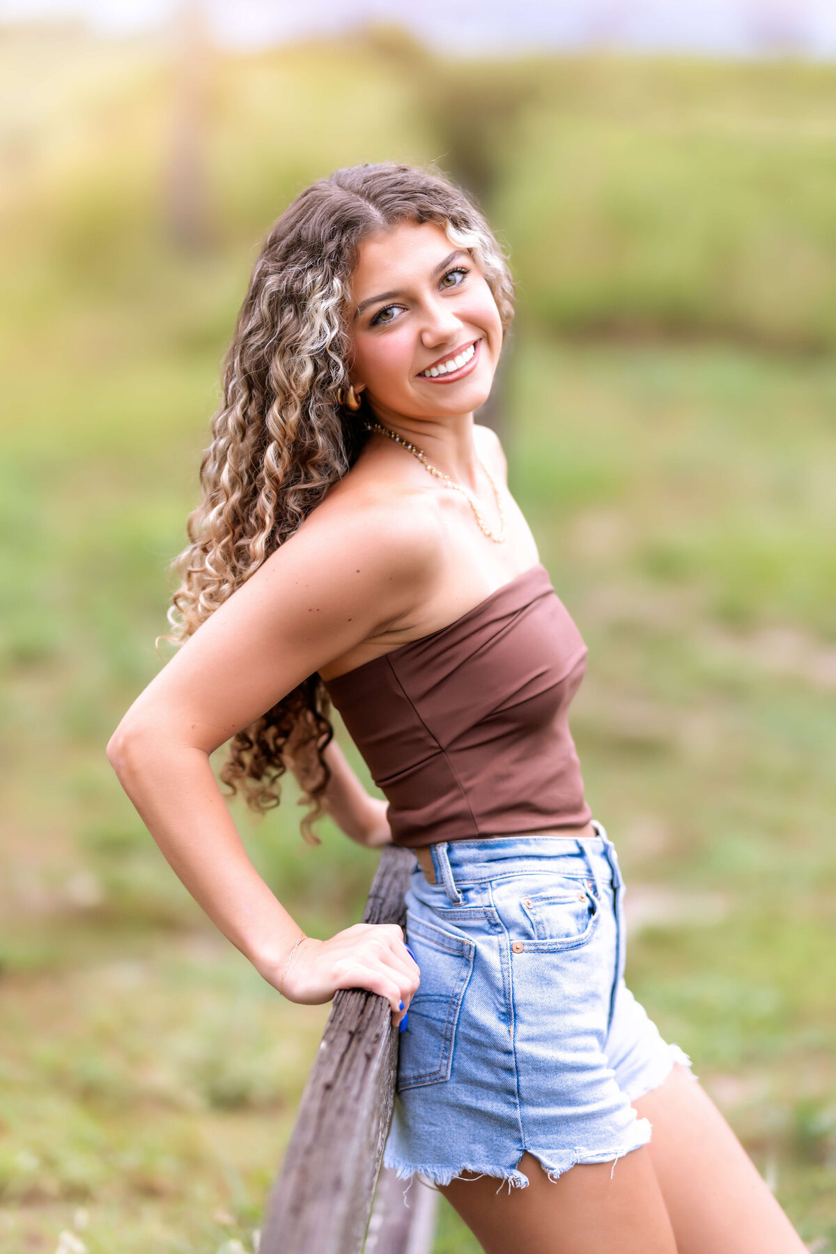 Smiling teen girl photographed in warm golden-hour light during her Orlando senior photo session.