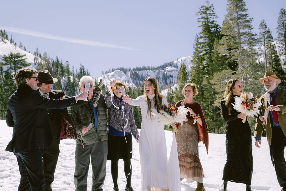 Champagne toast during winter Tahoe elopement at palisades
