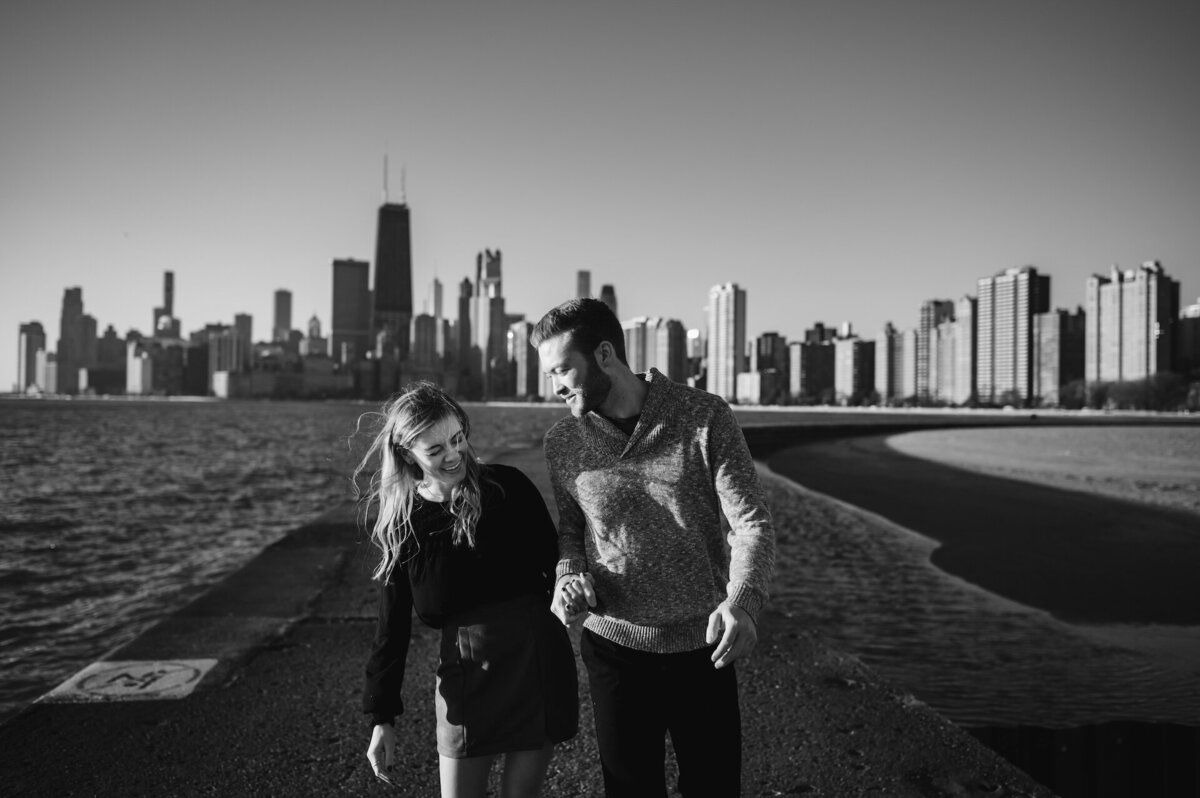 A couple laugh while walking on the bath at North Avenue Beach in Chicago