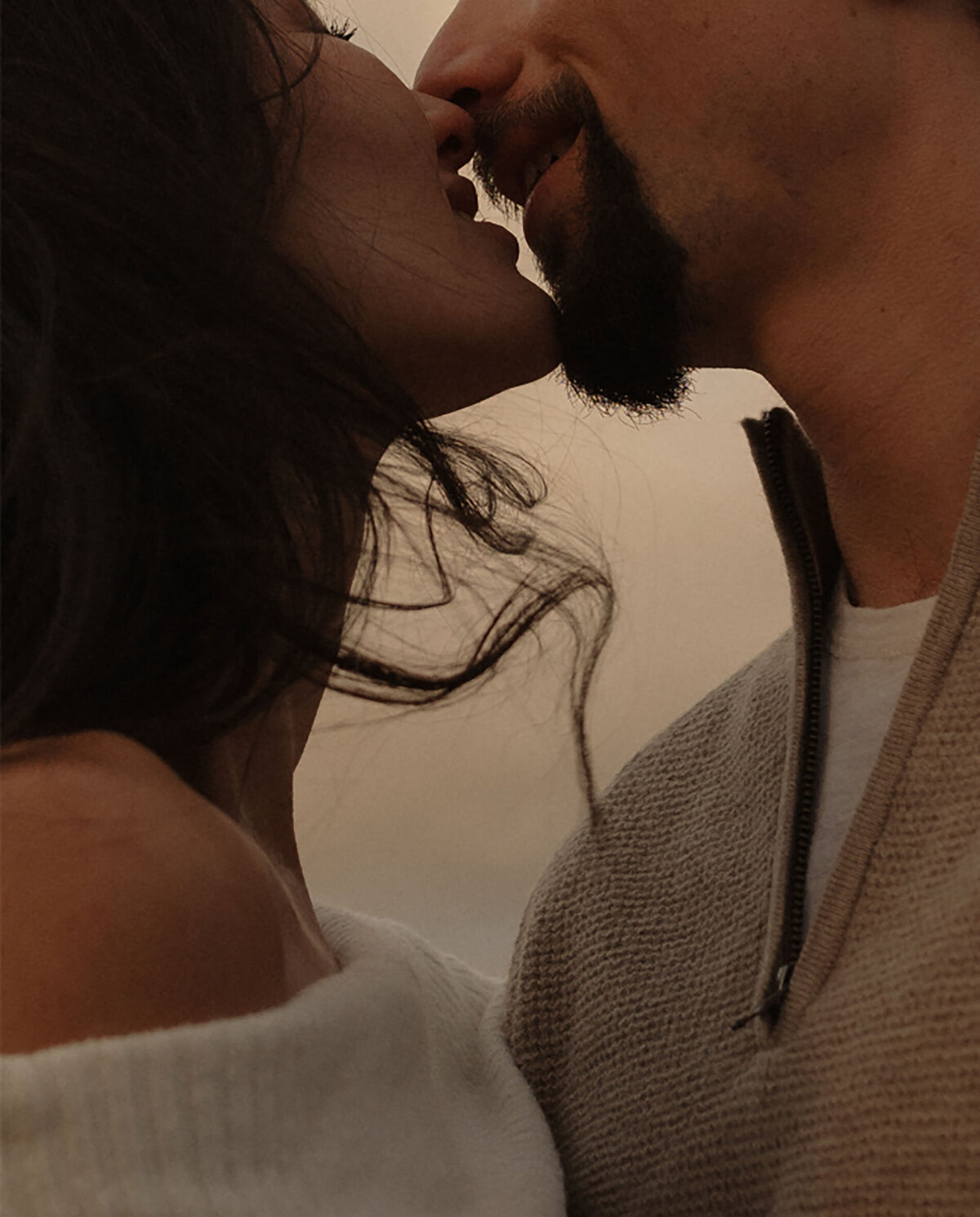 engagement couple share a special moment while they kiss with the wind in their hair at Smith Rock State Park