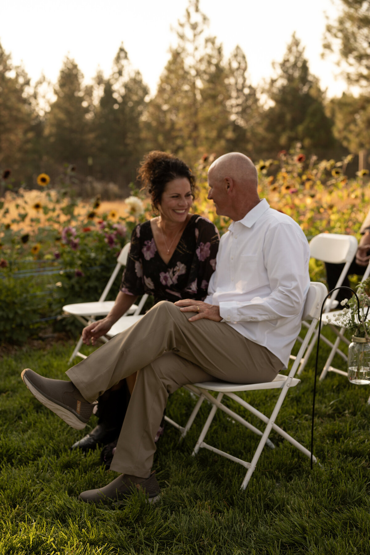 Mom and dad of groom smiling while groom walks down the isle taken by Idaho wedding photographer.