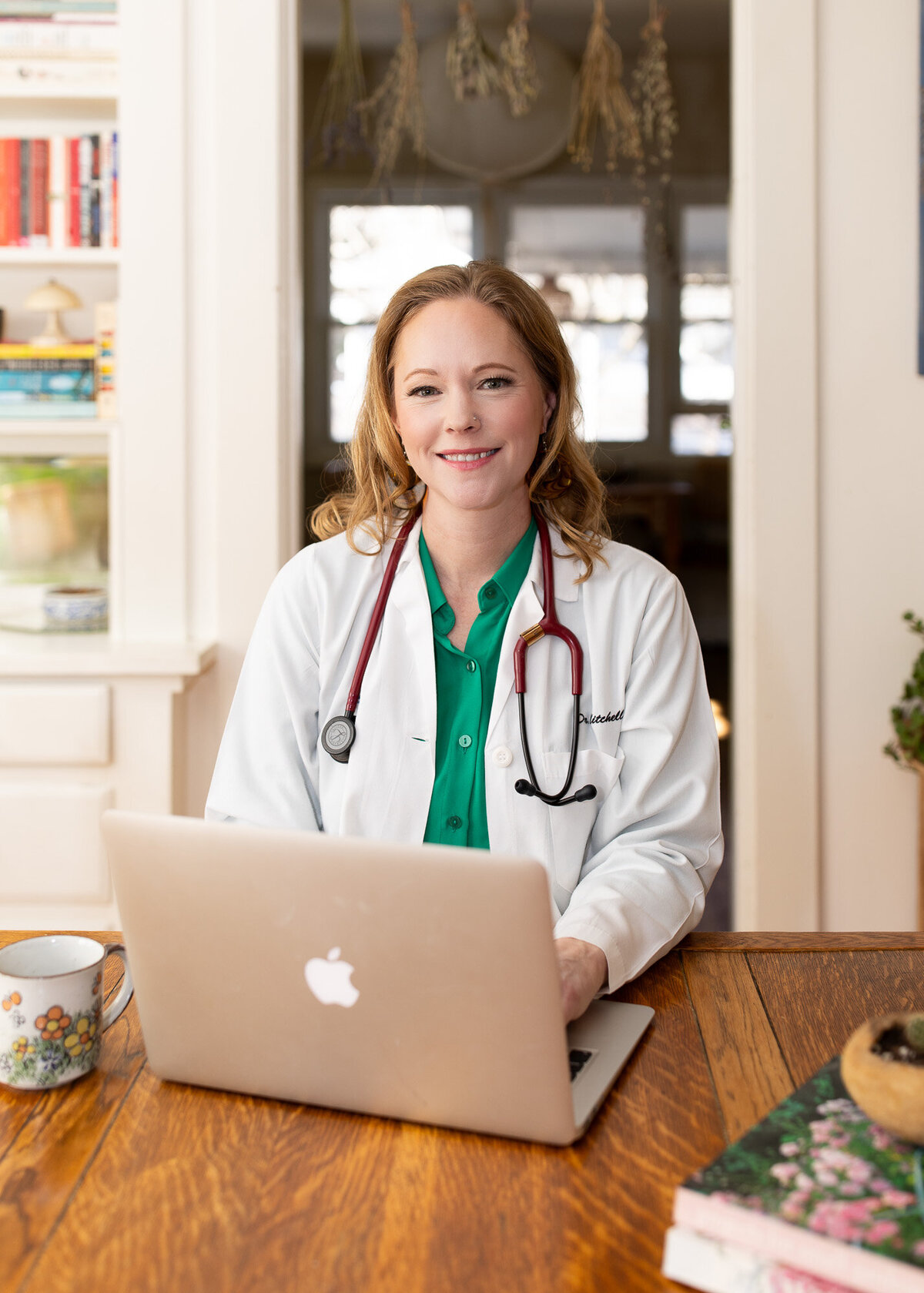 Physician portrait as she sits at desk with her laptop. 