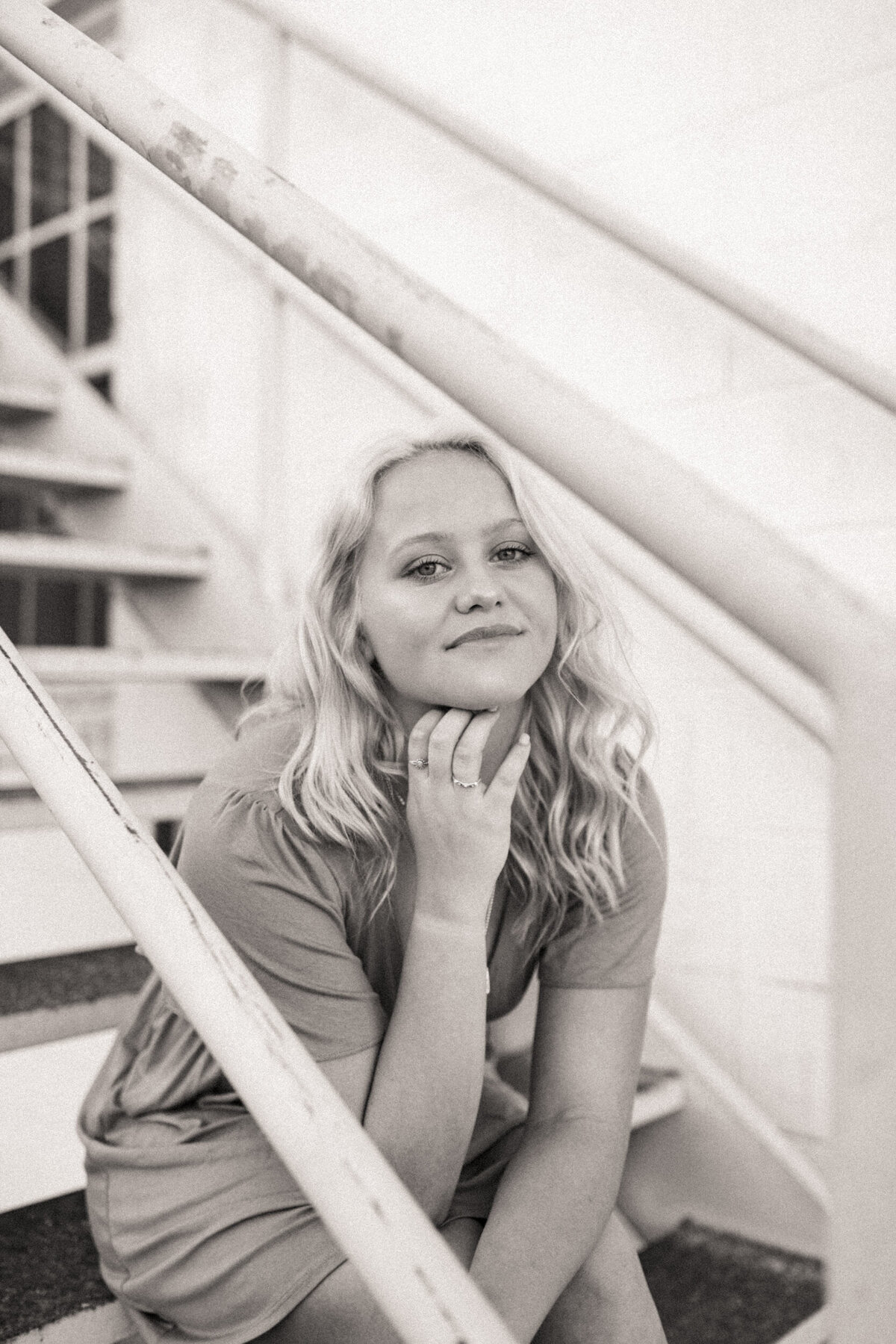 Girl senior sitting on a staircase in an alleyway downtown