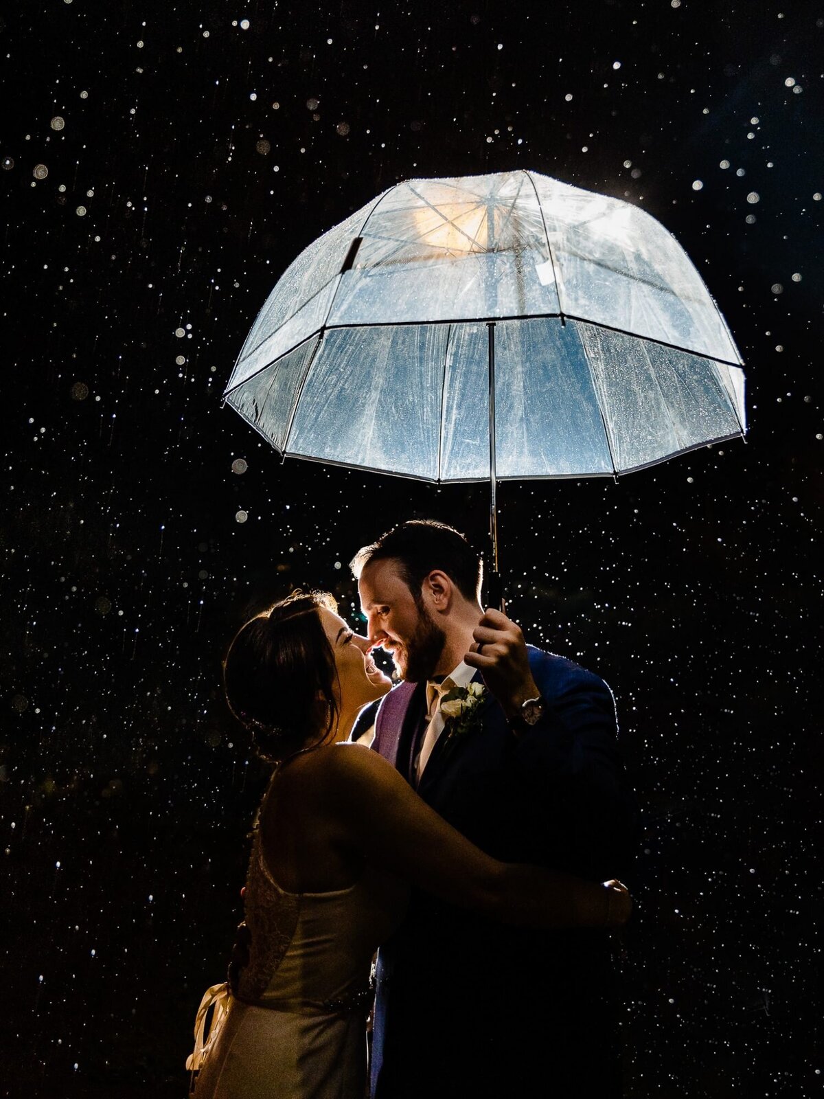 bride-and-groom-under-umbrella-in-rain-austin-wedding-photographer-john-winters-1500x2000-1