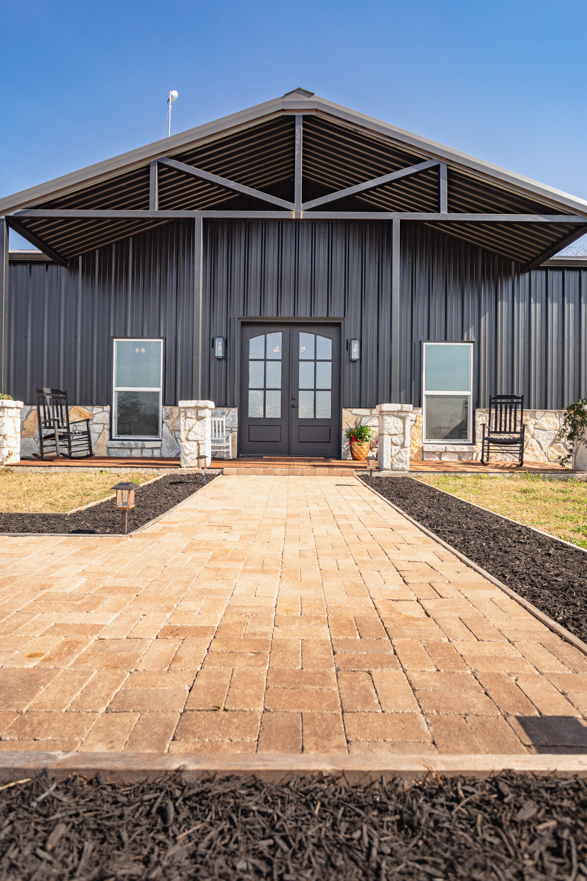 Front view of the main entrance of this five-bedroom, 3-bathroom vacation rental house for up to 10 guests with free wifi, private parking, outdoor games and seating, and bbq grill on 2 acres of land near Waco, TX.