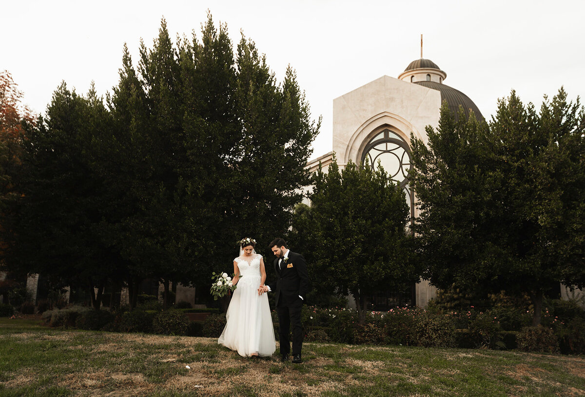 bride and groom holding hands outside a church