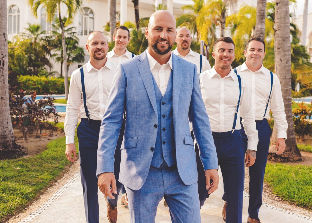 Groom and groomsmen walking on path at wedding in Riviera Maya