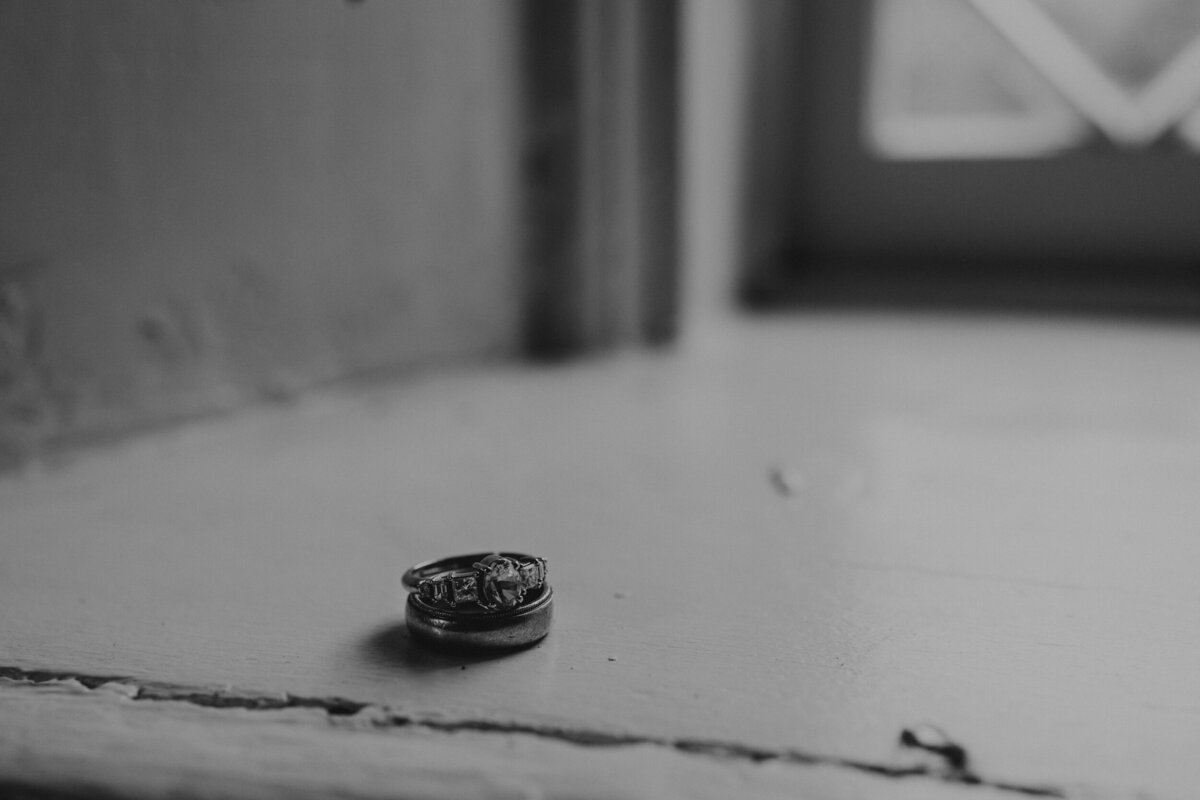 bride and grooms rings on a window ledge in black and white