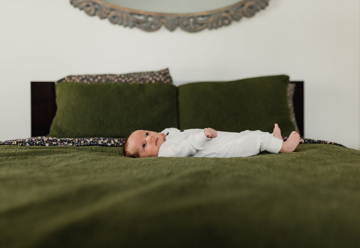 Newborn baby laying on a bed