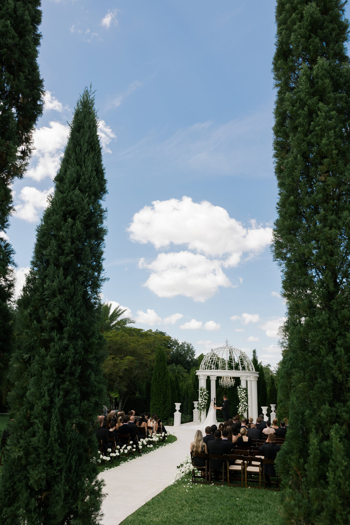 Outdoor wedding ceremony under white pergola at La Casa Toscana in Fort Myers