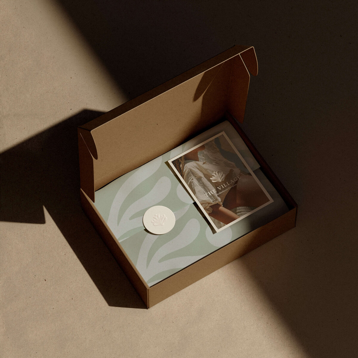 Custom mailer box packaging design for Village Motherhood Co featuring maternal wellness branding.