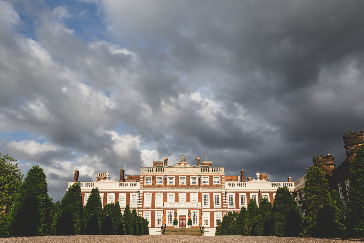 An exterior photograph of Knowsley hall with dramatic clouds in the background