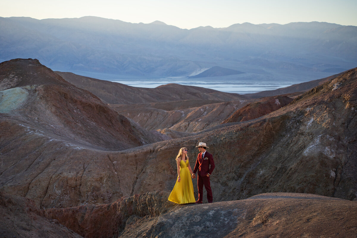 A couple standing on colored rocks in the desert