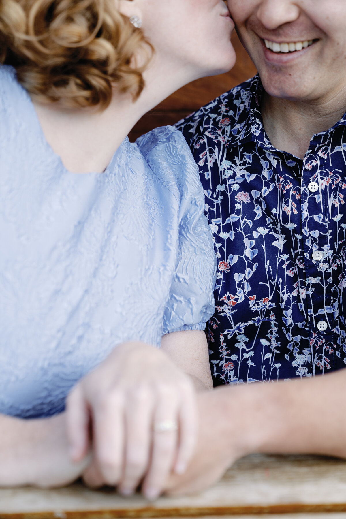 Whimsical engagement photoshoot at San Francisco pier, capturing a lighthearted kiss between the couple amidst their playful connection