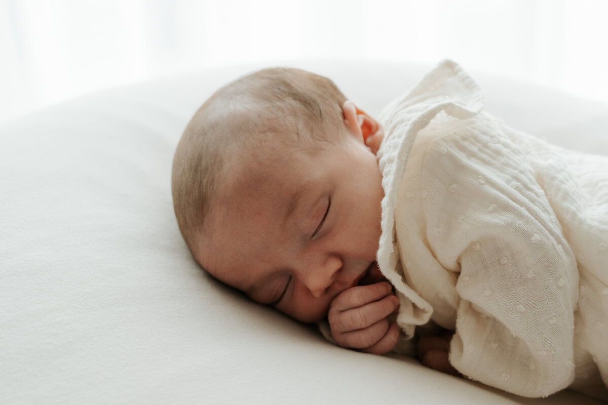 Baby ligt op de buik tijdens haar newbornshoot aan huis in Sint-Katelijne-Waver