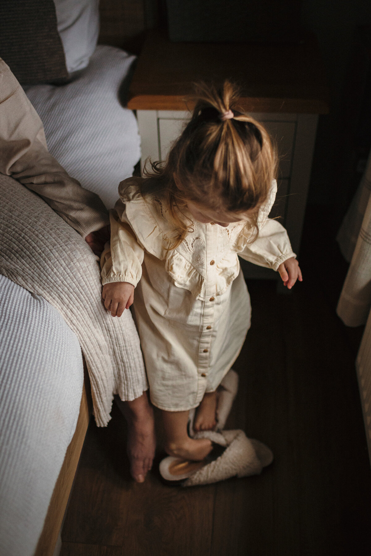 Young girl tries on Mum's slippers