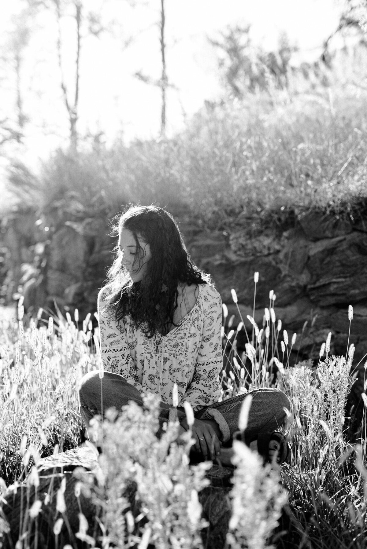 black and white high school portrait among the natural flowers in  a field