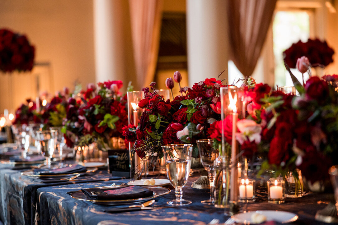 red roses, black and gold linen, gold charger, black napkin, taper candles, red roses, 