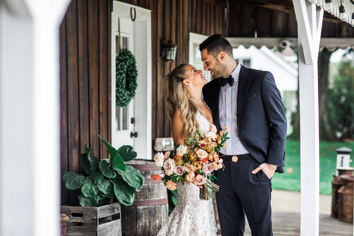 An elegant fall bridal bouquet featuring a sunset color palette of blush, terra cotta, rose gold, yellow, and copper. Florals accents of dahlias, garden roses, ranunculus, and double brownie tulips. Designed by Rosemary and Finch in Nashville, TN.