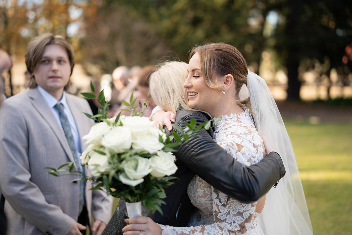candid moment of someone hugging the bride