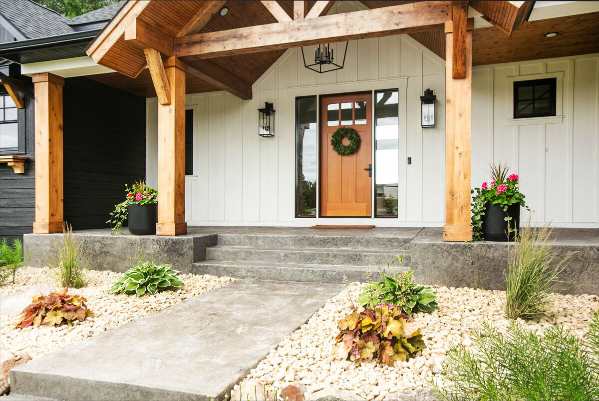 Exterior view of custom home in Otsego, Minnesota with modern wood details and front porch built by Cornerstone Custom Builds