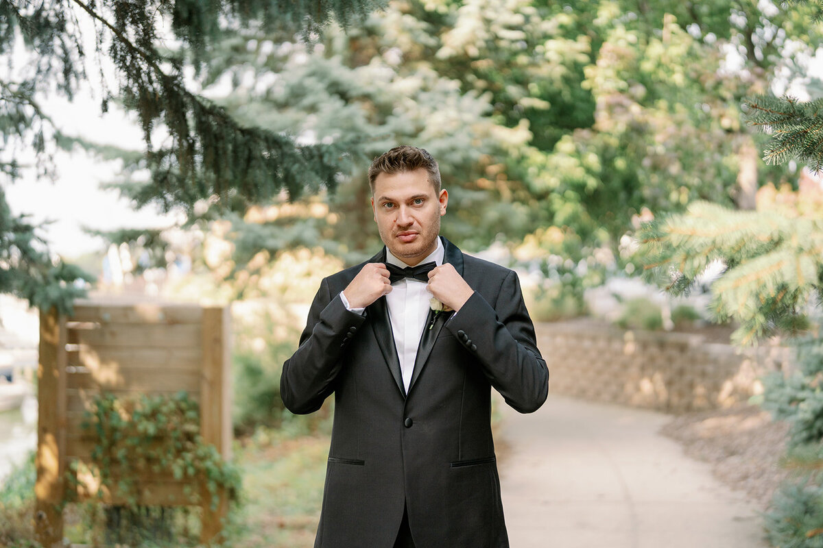 Black tie wedding couple posing outside Boatwerks Waterfront Venue in Holland Michigan with elegant timeless photography.