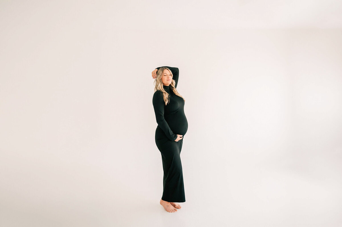 pregnant mom holding baby bump closing eyes captured by Springfield MO maternity photographer Jessica Kennedy of The XO Photography