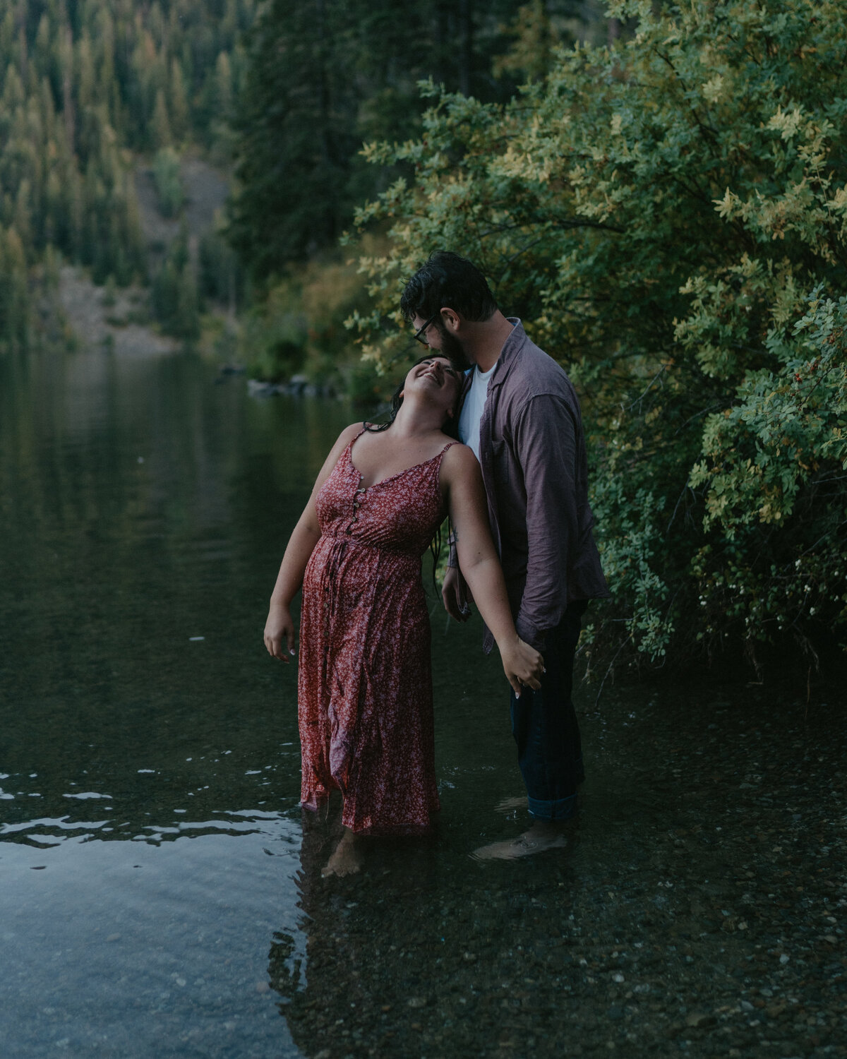 A couple shares a quiet moment by the water during their lakeside engagement session in Washington, capturing serenity and connection.