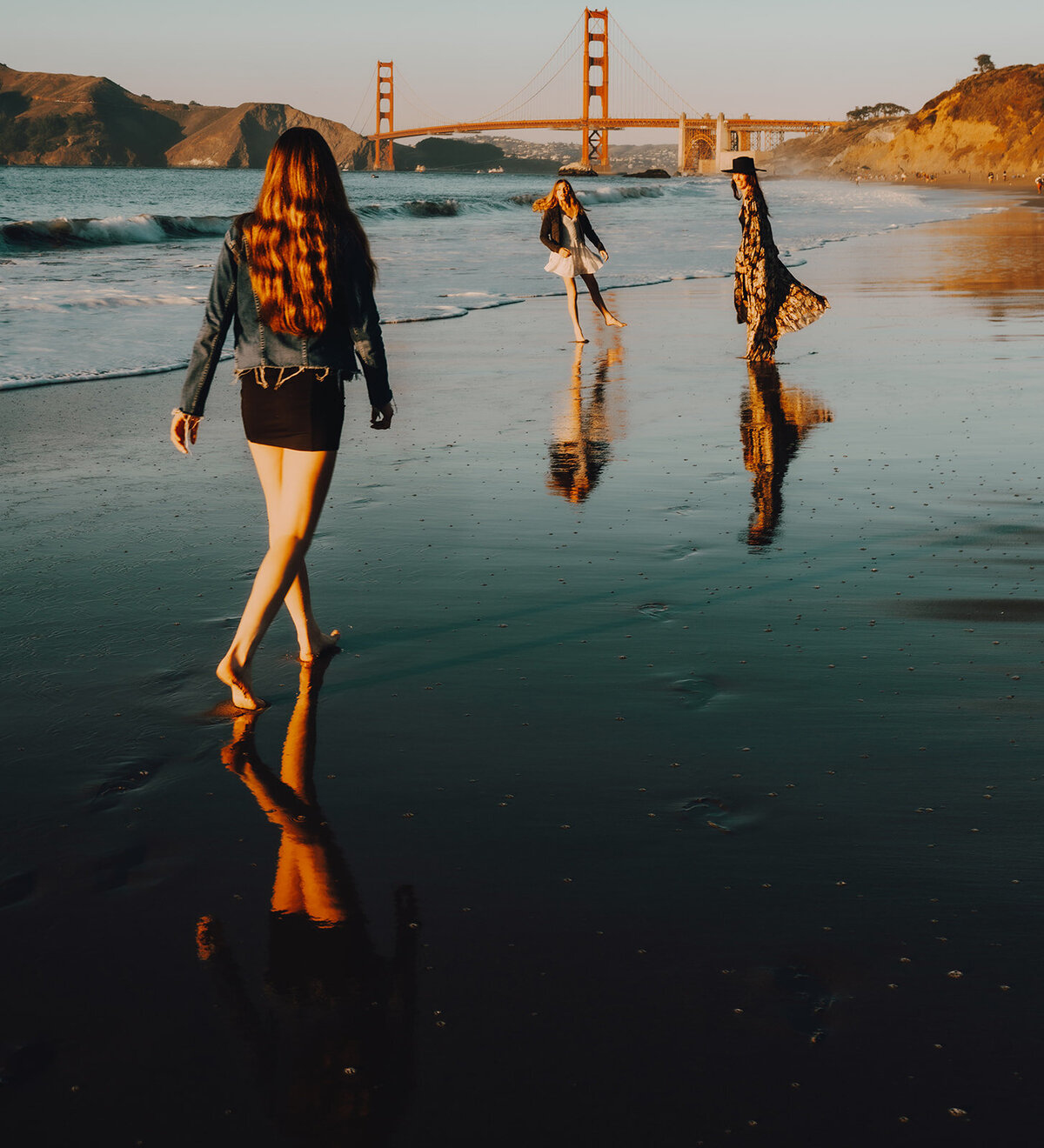 Reflection of a family on a beach with the golden gate bridge in the background