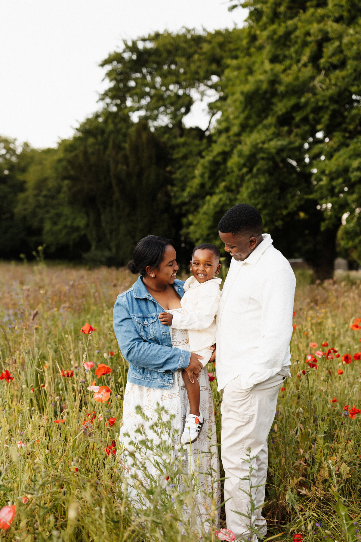 a mum wears a denim jacked and her husband and son wear white and beige while they're photographed by lucy jane photography in christchurch