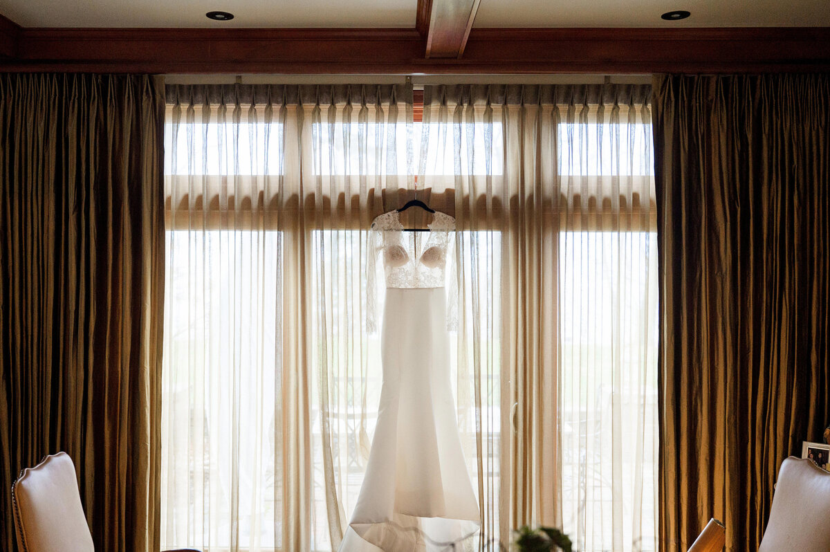 wedding dress hanging in window