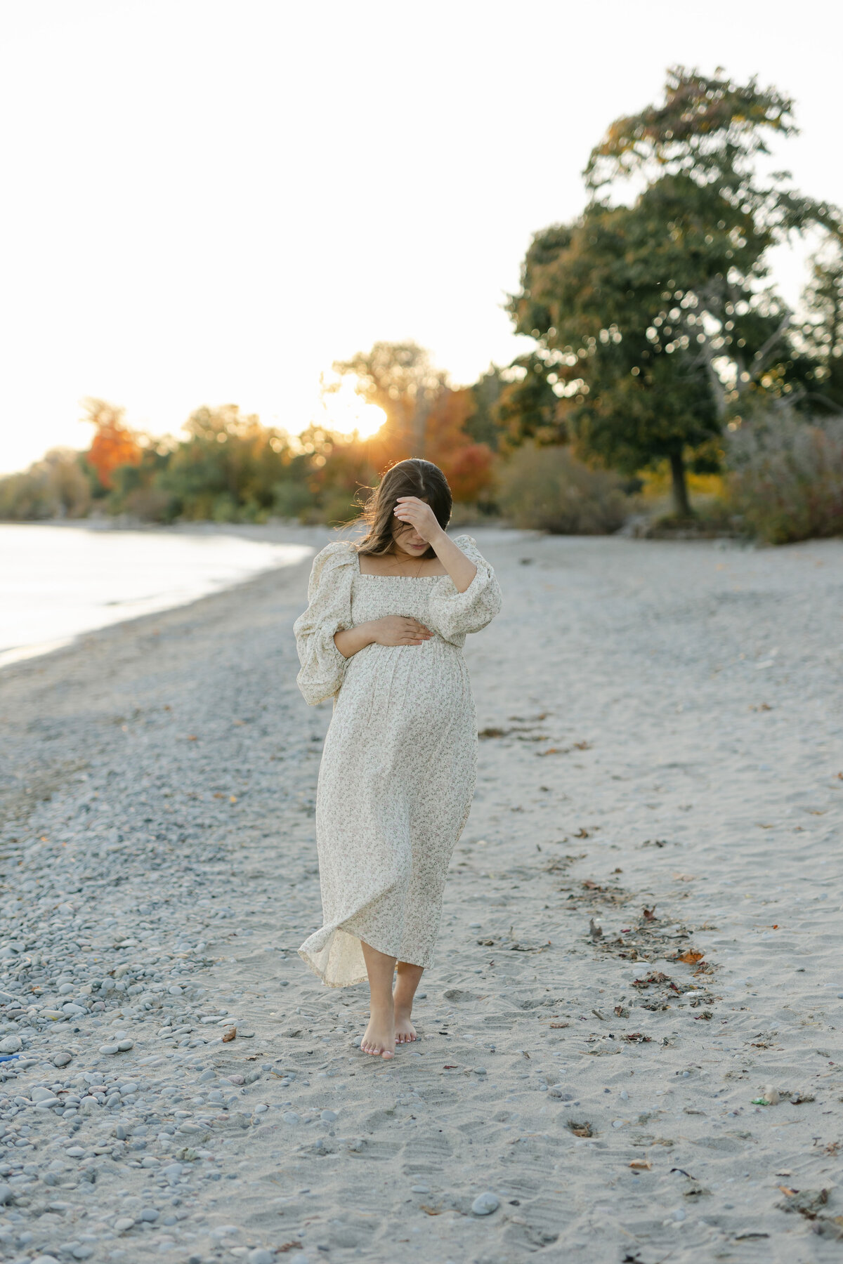 pregnant woman walking on a beach by Toronto Maternity Photographer