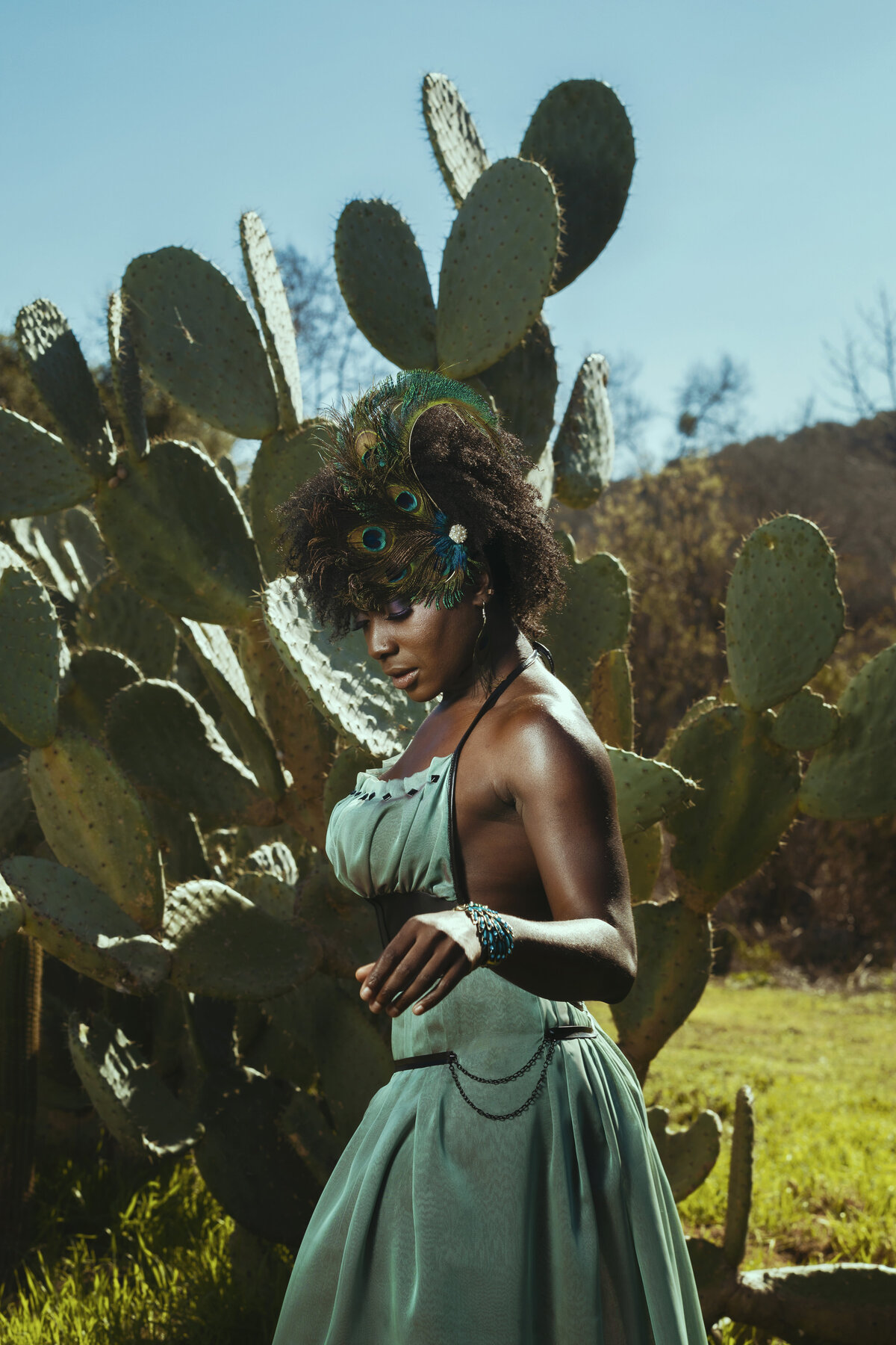 Black woman in green out standing in front of cactus