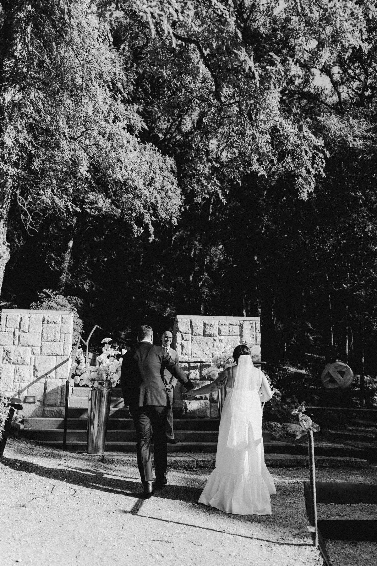 Bride and groom walking along hand in hand at Umlauf Sculpture Garden Wedding, Austin