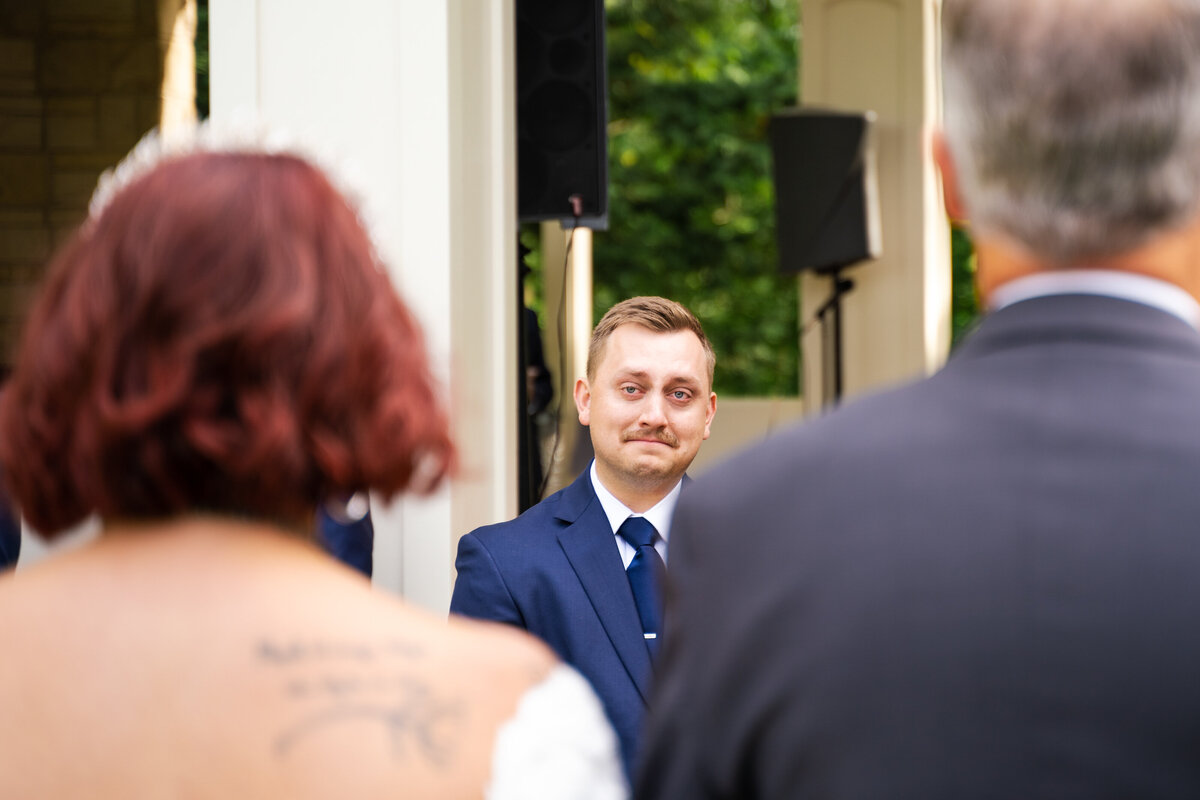 Groom cries as he looks at his bride who just walked down the aisle at their wedding at Fellows Riverside Gardens in Youngstown, Ohio.