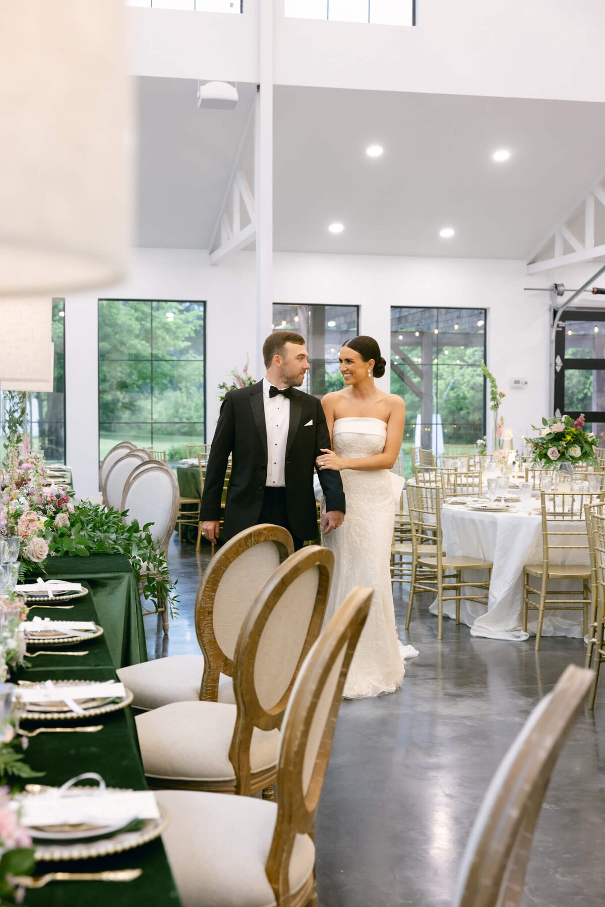 A wedding day photo of the bride and groom posing for a photo in the wedding reception area