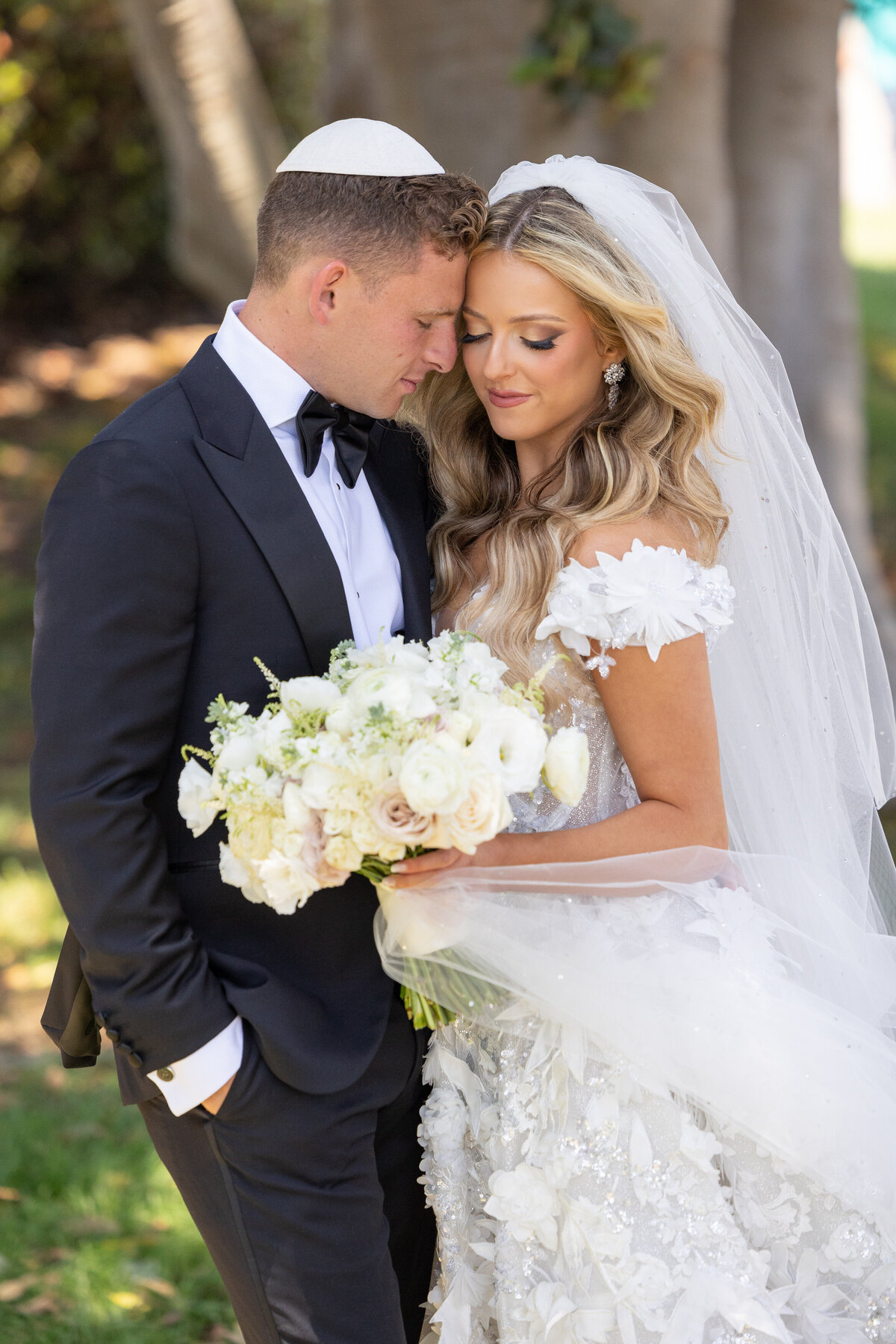 A groom resting his head on a brides head