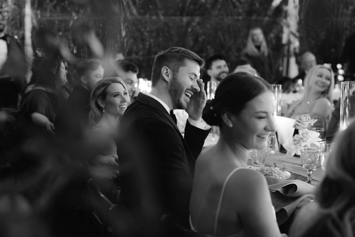 Bride and groom laugh during wedding toasts