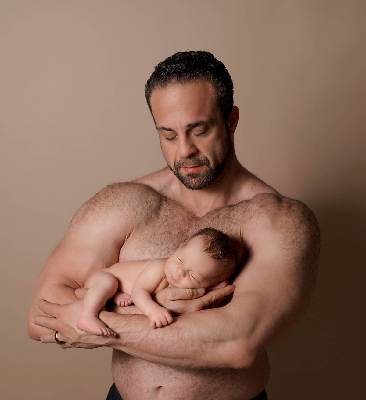 Father holding his newborn for photoshoot